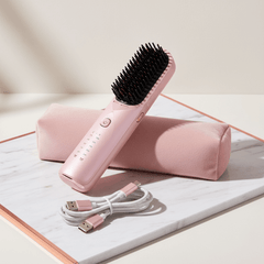 Brosse Lissante Sans Fil Douchity sur un support avec câble USB rose, conçue pour lisser les cheveux rapidement.